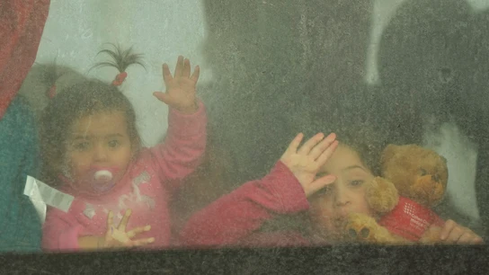 Dos niñas ucranianas saludan desde el autobús mientras cruzan el paso fronterizo de Moldavia a Rumanía. Dos niñas ucranianas saludan desde el autobús mientras cruzan el paso fronterizo de Moldavia a Rumanía.