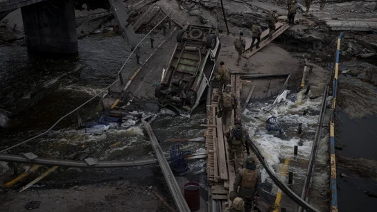 Soldados ucranianos cruzan un puente improvisado entre los escombros de un bombardeo en Irpín, a las afueras de Kiev. Soldados ucranianos cruzan un puente improvisado entre los escombros de un bombardeo en Irpín, a las afueras de Kiev.