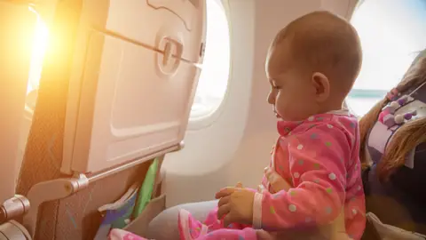 Un bebé viajando en avión Un bebé viajando en avión