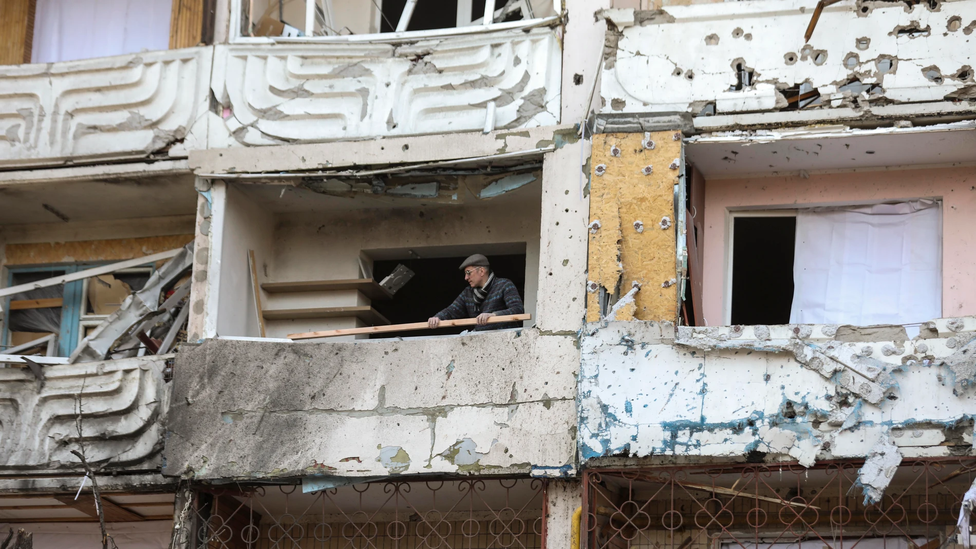 Un hombre limpia los escombros de un edificio dañado por los bombardeos en Kiev, Ucrania, el 15 de marzo de 2022
