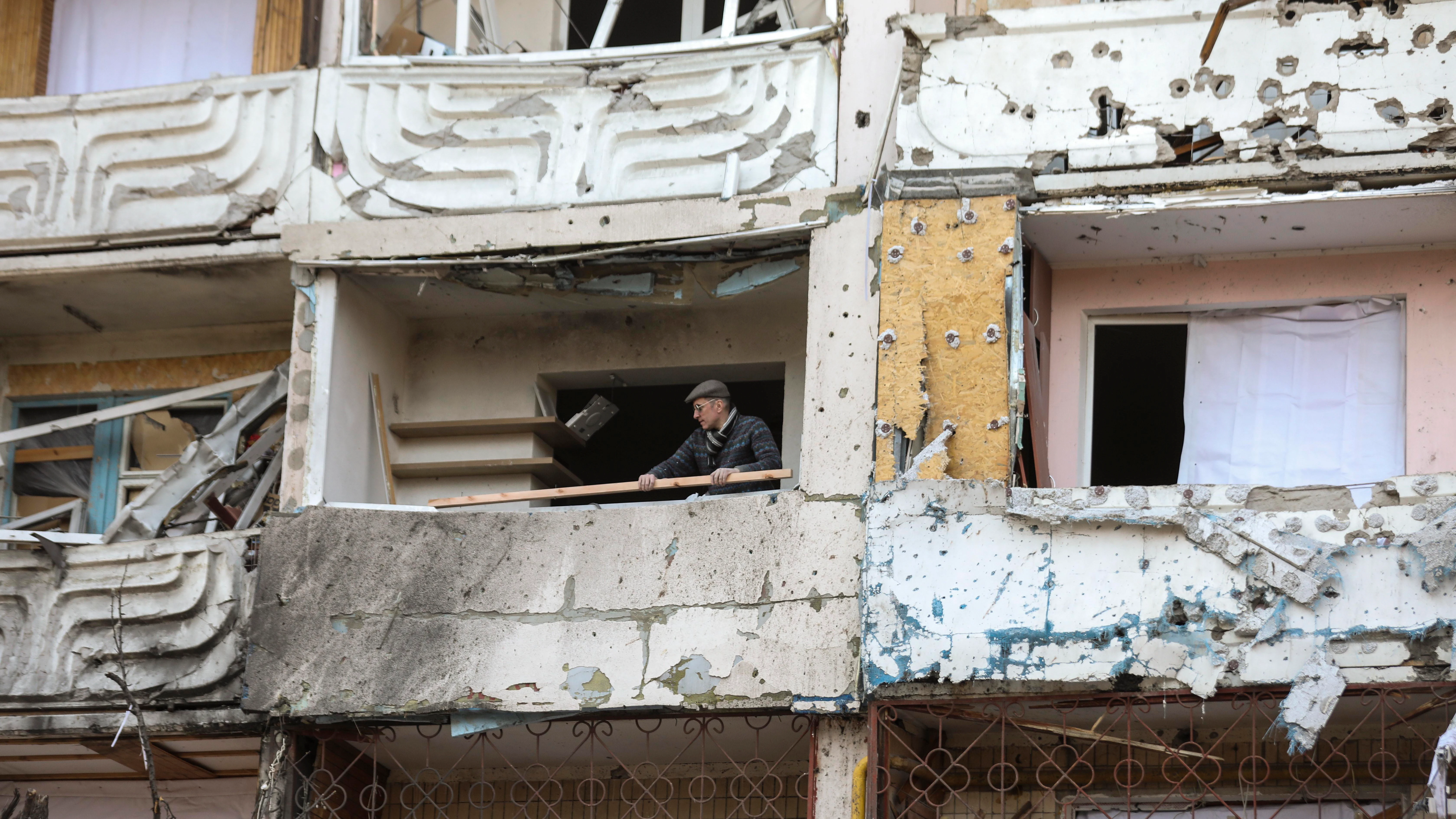 Un hombre limpia los escombros de un edificio dañado por los bombardeos en Kiev, Ucrania, el 15 de marzo de 2022 