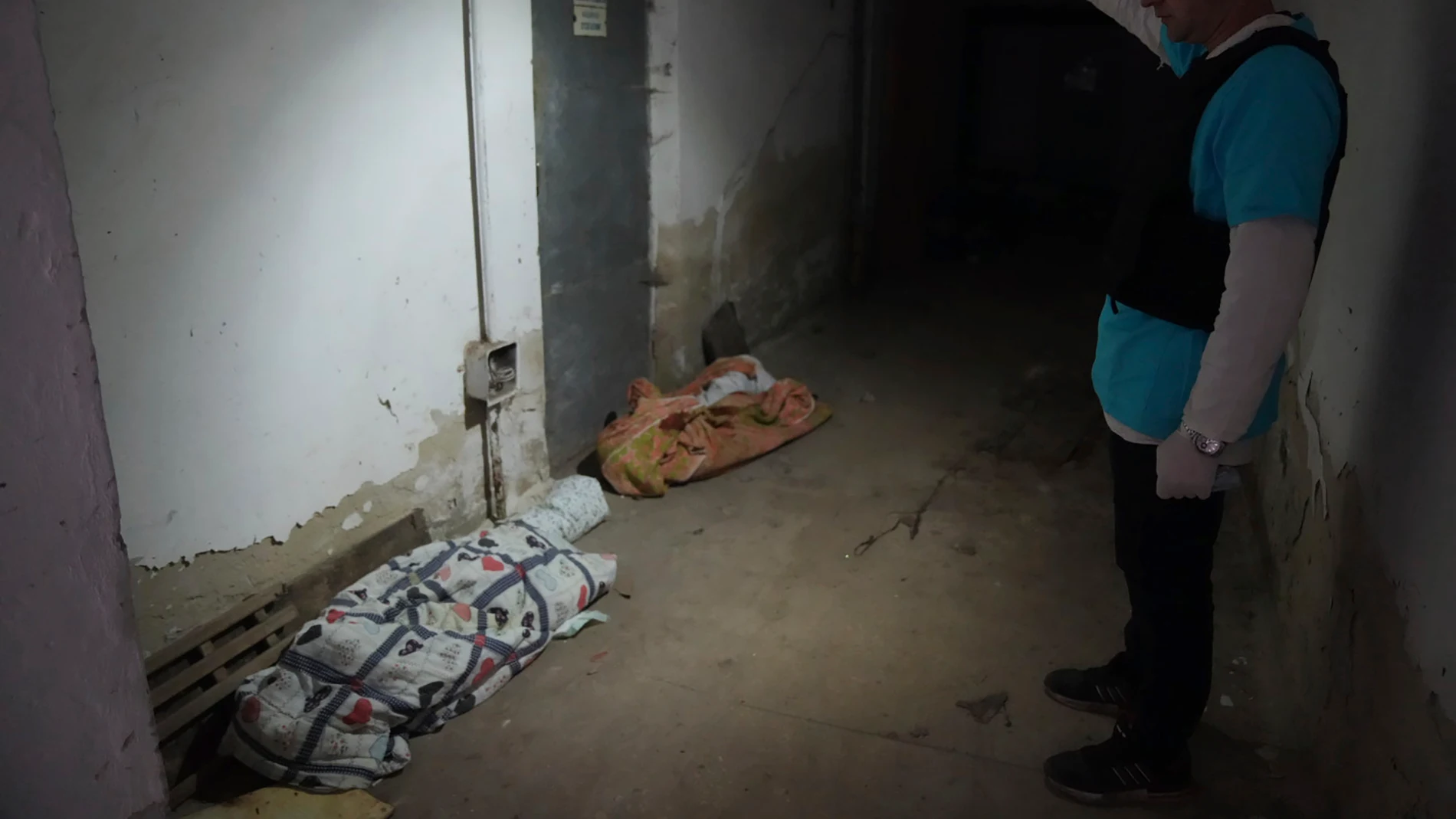 Un policía muestra los cuerpos cubiertos de los niños muertos por los bombardeos en el hospital número 3 de Mariupol.