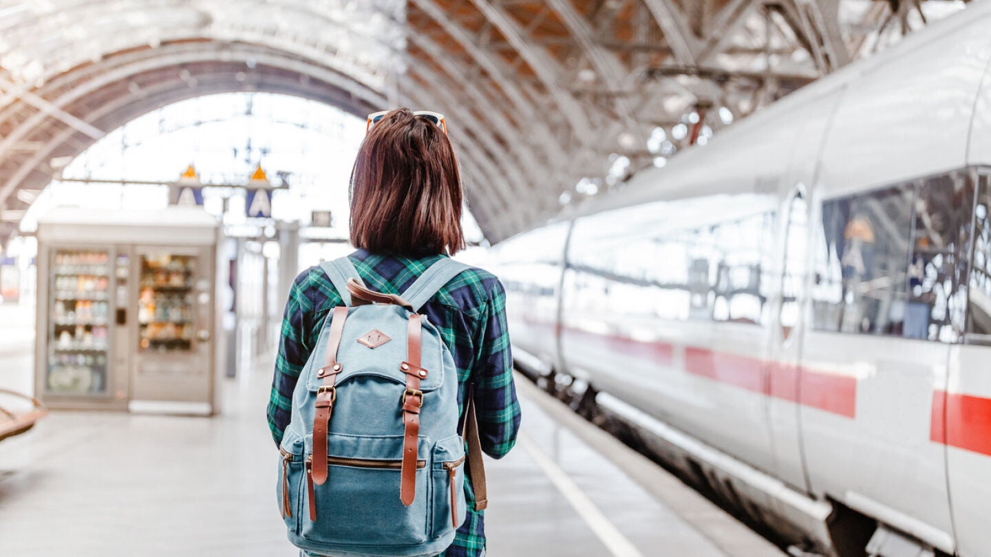 Joven en una estación de tren a punto de viajar