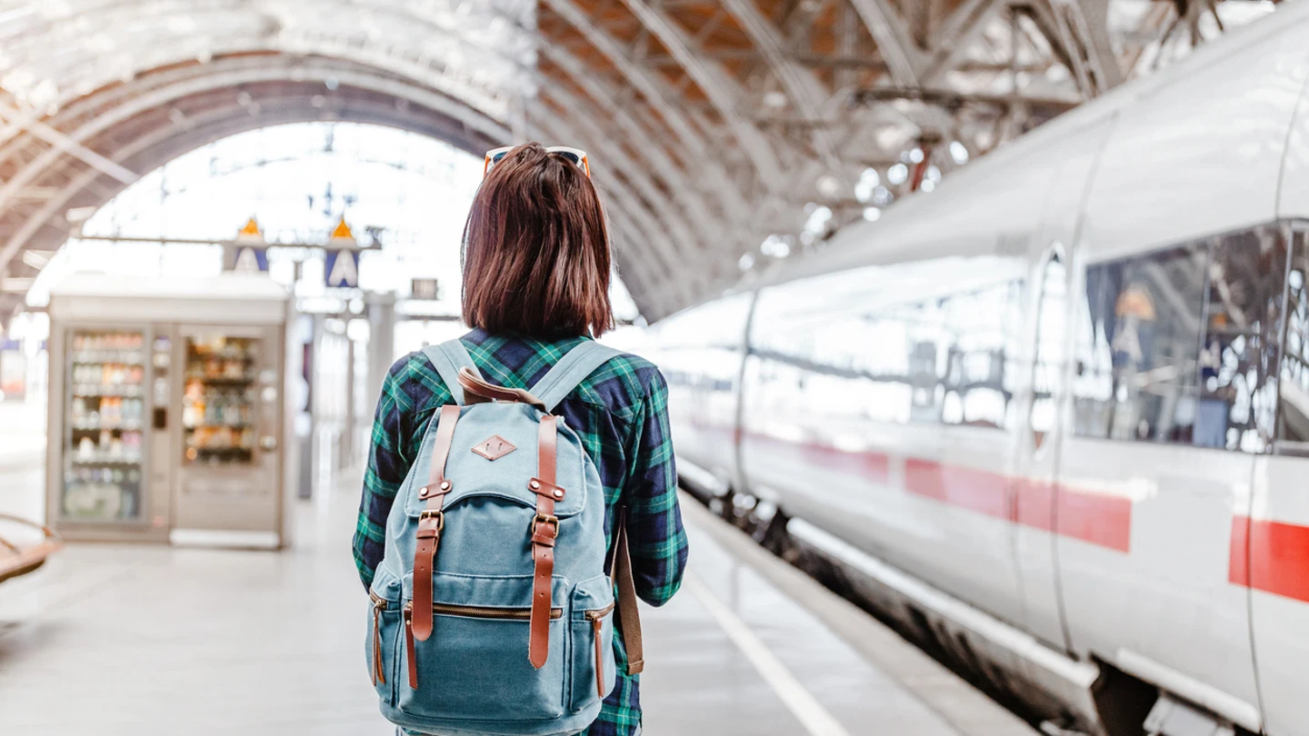 Joven en una estación de tren a punto de viajar Joven en una estación de tren a punto de viajar