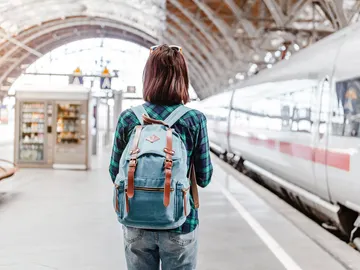Joven en una estación de tren a punto de viajar Joven en una estación de tren a punto de viajar