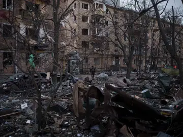 Un oficial de policía camina en el lugar de un bombardeo que dañó edificios residenciales en Kiev, Ucrania.