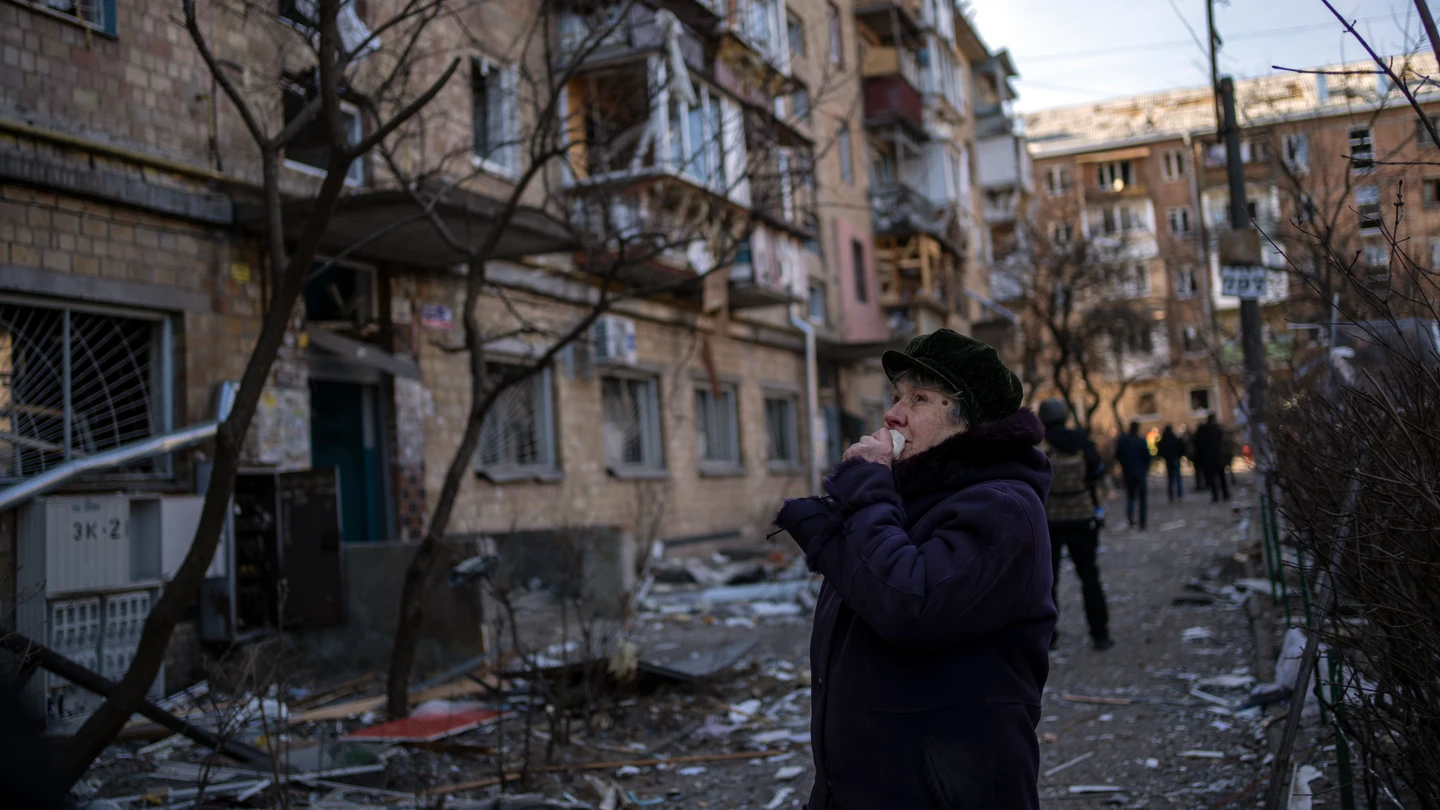 Una mujer mira los edificios residenciales dañados por una bomba en Kiev, Ucrania Una mujer mira los edificios residenciales dañados por una bomba en Kiev, Ucrania