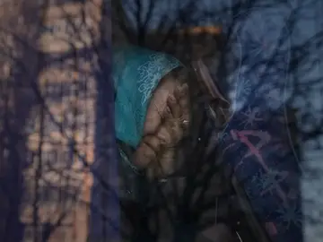Una refugiada ucraniana llora en el autobús que la evacúa de Ucrania.