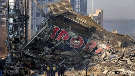 La gente examina los daños después del bombardeo de un centro comercial, en Kiev, Ucrania La gente examina los daños después del bombardeo de un centro comercial, en Kiev, Ucrania
