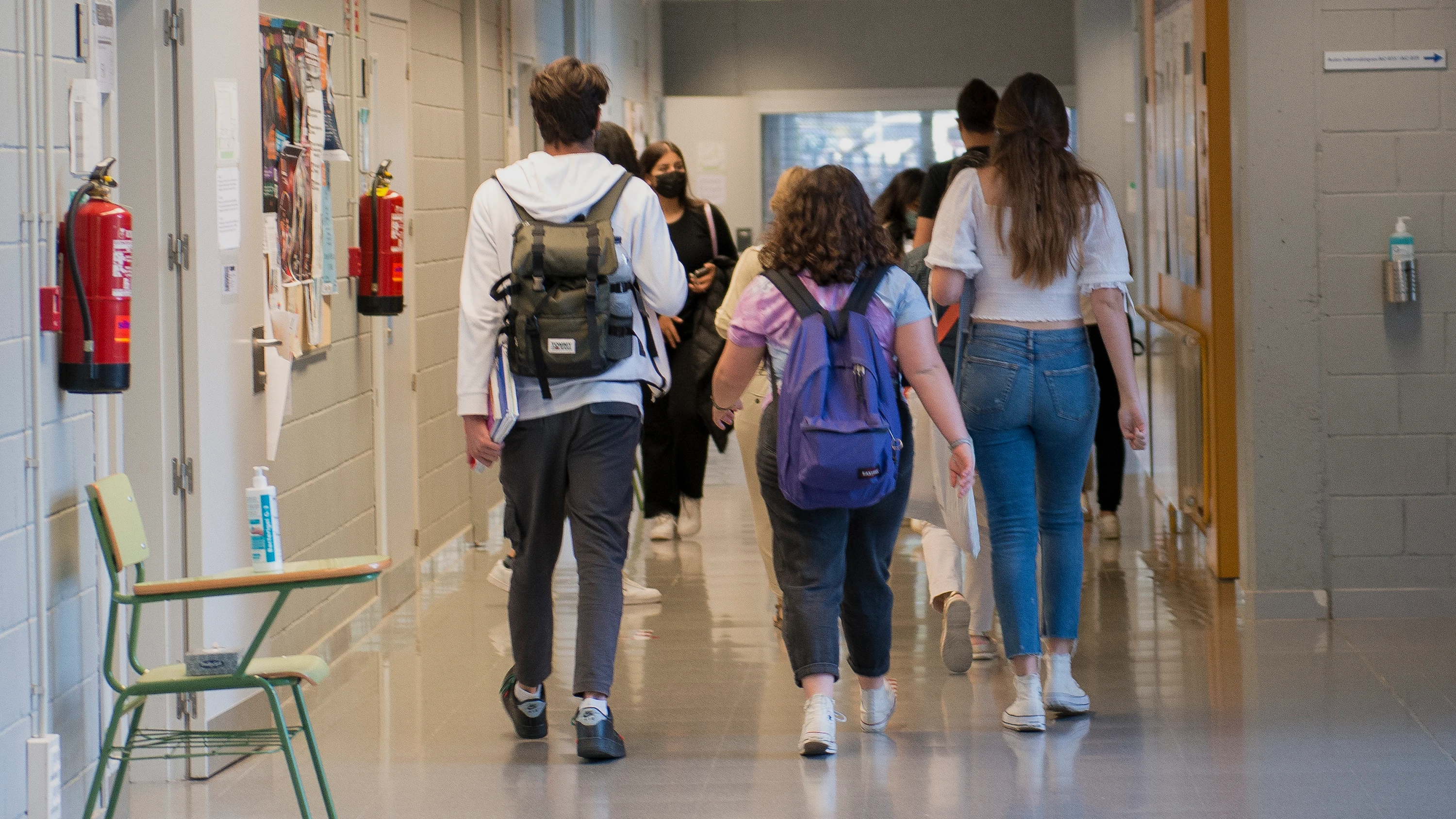 Un grupo de estudiantes camina por los pasillos de un centro educativo.