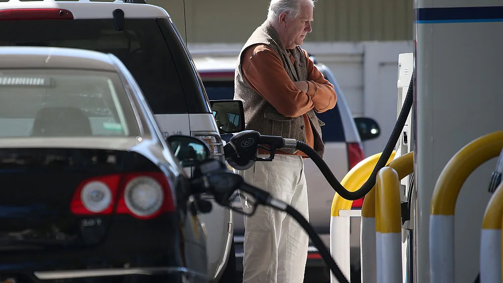 Imagen de archivo de un hombre echando gasolina en una gasolinera