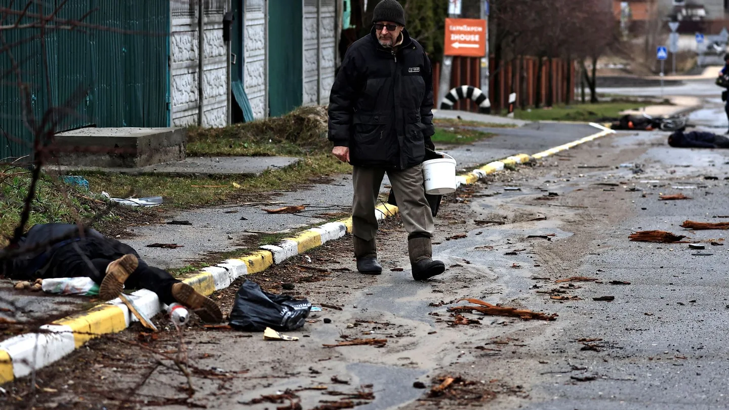 Vasily, de 55 años, pasa junto al cuerpo de un pariente, que según él fue asesinado por soldados del ejército ruso, en Bucha. Crímenes de guerra