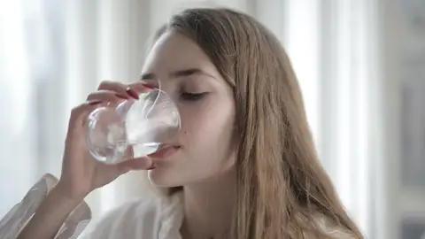 Mujer bebiendo un vaso de agua. Mujer bebiendo un vaso de agua.