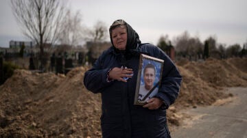 Una mujer sostiene el retrato de un civil asesinado en Bucha.