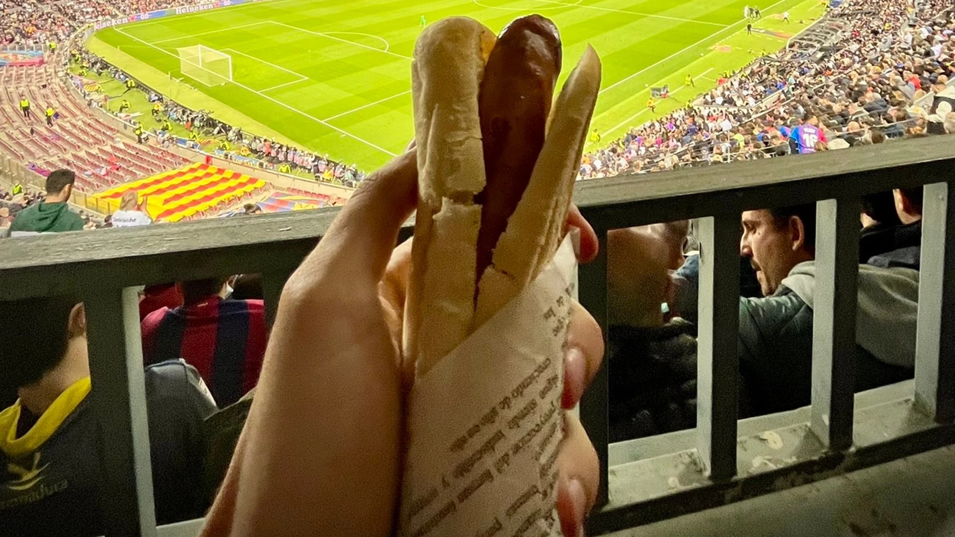 Un aficionado comiendo una salchicha en el Camp Nou