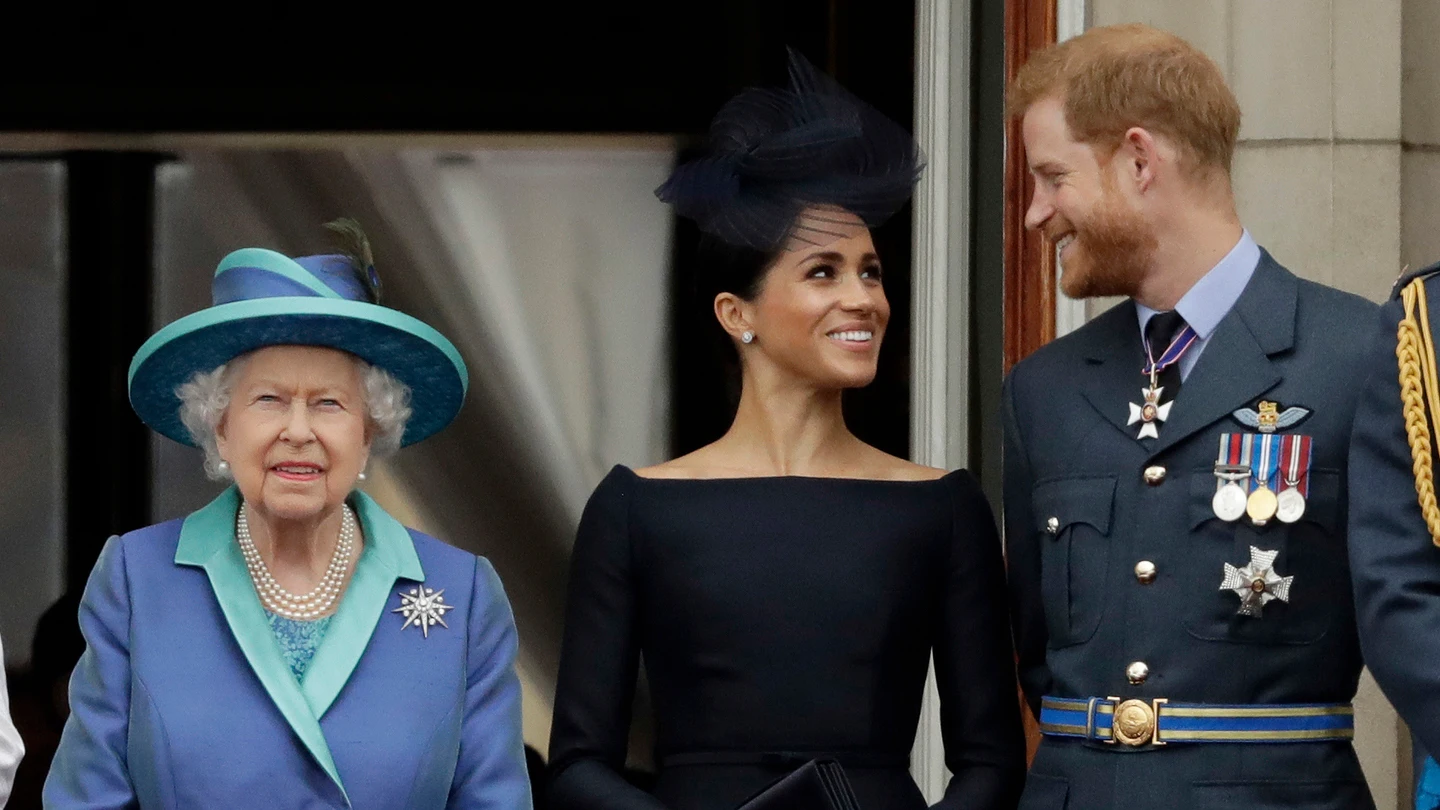 Meghan Markle y el príncipe Harry, sonrientes tras la reina Isabel II en una imagen de 2018 Meghan Markle y el príncipe Harry, sonrientes tras la reina Isabel II en una imagen de 2018