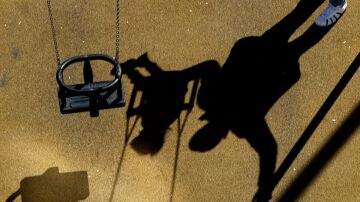 Imagen de archivo de la sombra de una niña en un columpio