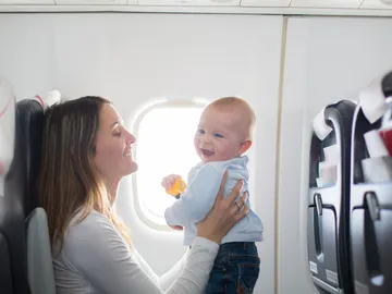 Madre con su bebé en un avión Madre con su bebé en un avión