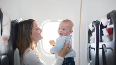 Madre con su bebé en un avión Madre con su bebé en un avión