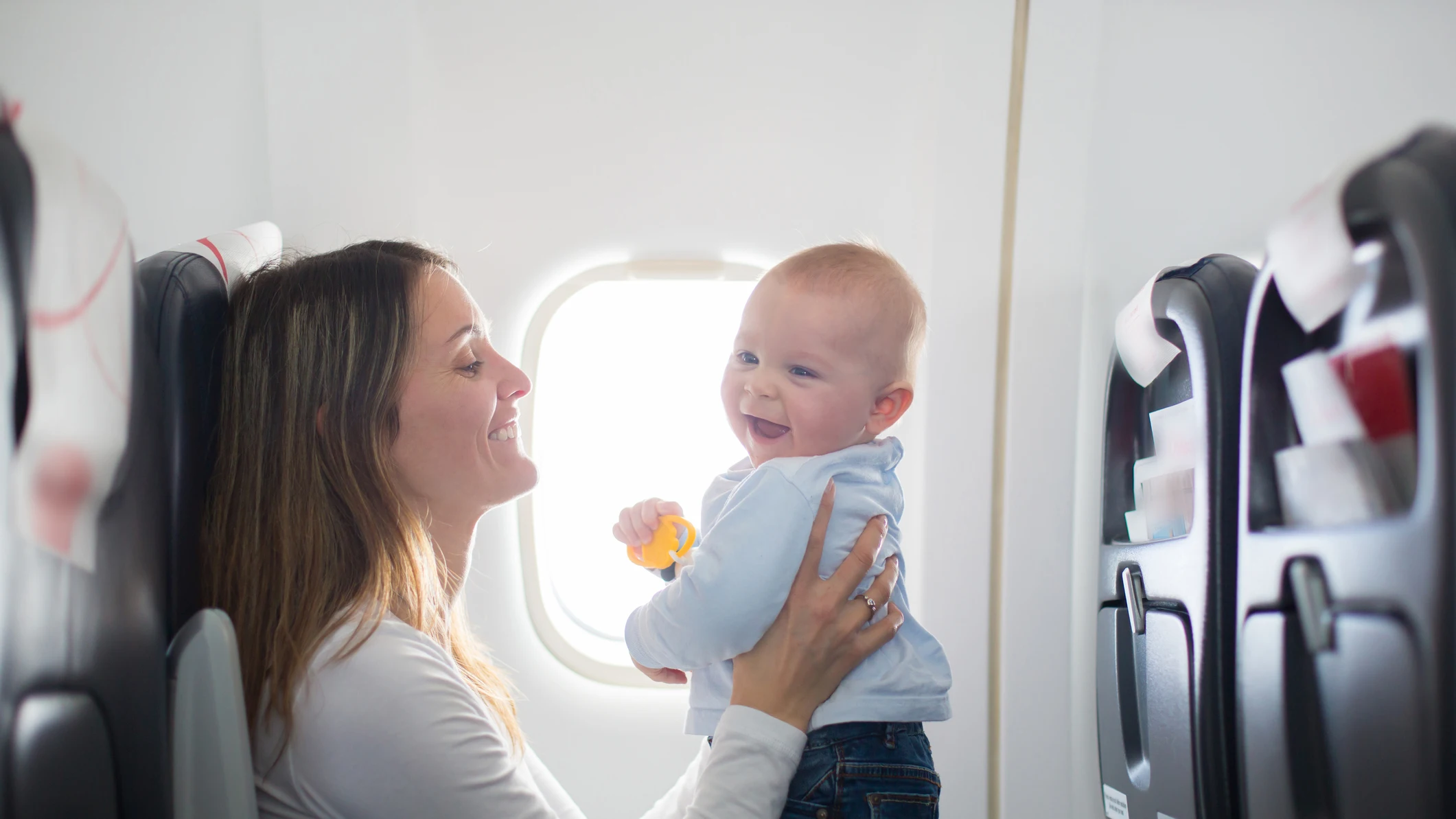 Madre con su bebé en un avión Madre con su bebé en un avión