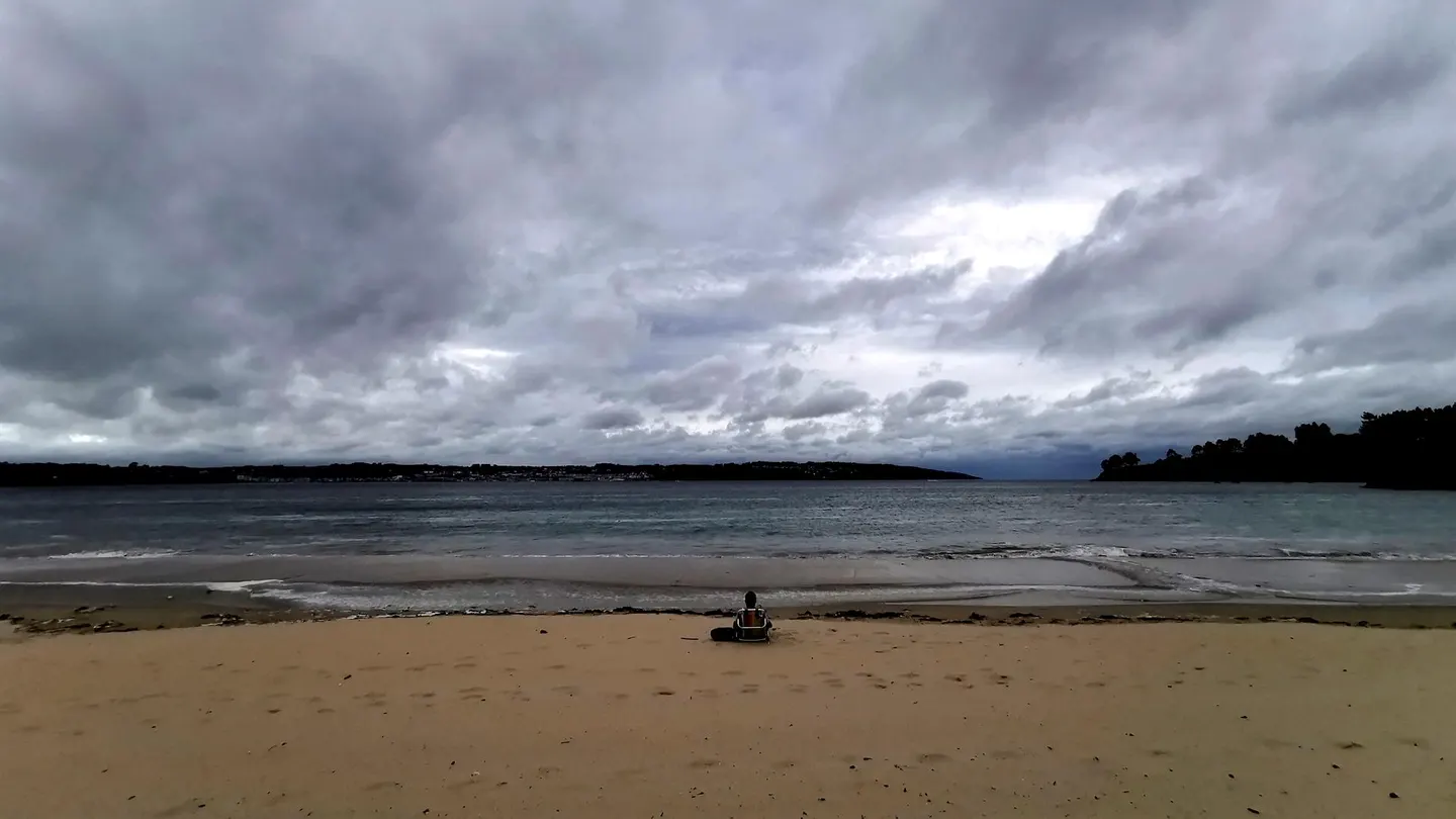 Un hombre descansa en la playa Grande de Miño, en A Coruña, en una foto de archivo Un hombre descansa en la playa Grande de Miño, en A Coruña, en una foto de archivo