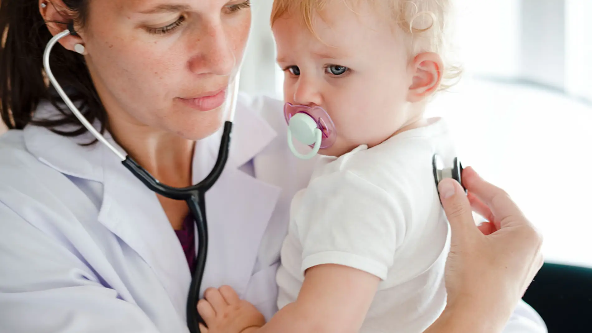 Bebé con chupete visitando al médico