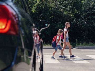 niños cruzando una calle con tráfico