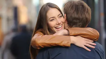Mujer abrazando alegremente a un hombre