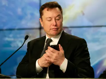 Elon Musk observa sorprendido su teléfono móvil