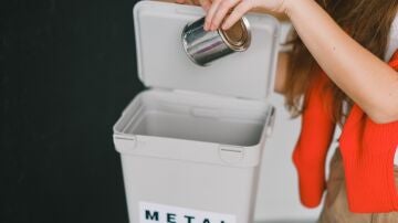 Imagen de archivo de una persona reciclando una lata de conserva