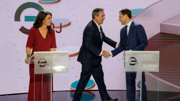 Juan Espadas y Juanma Moreno se saludan durante el debate previo a las elecciones en Andalucía. A su lado, Macarena Olona