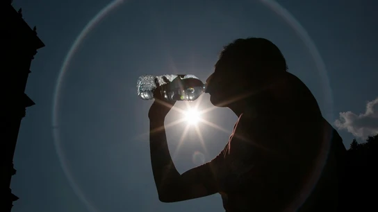 Una mujer bebe agua para hacer frente al calor Una mujer bebe agua para hacer frente al calor