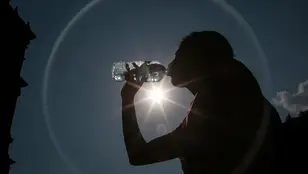 Una mujer bebe agua para hacer frente al calor