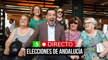El candidato del PP a la reelección en la Junta, Juanma Moreno, bromea con un grupo de mujeres durante un paseo por Granada cuando se celebran las fiestas del Corpus con el desfile de La Tarasca