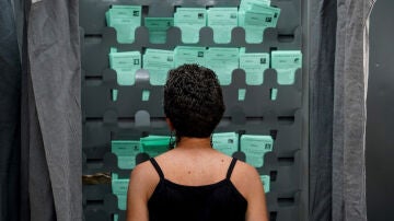 Una mujer observa las papeletas para ejercer su derecho al voto durante el día de las elecciones a la presidencia de la Junta de Andalucía a 19 de junio