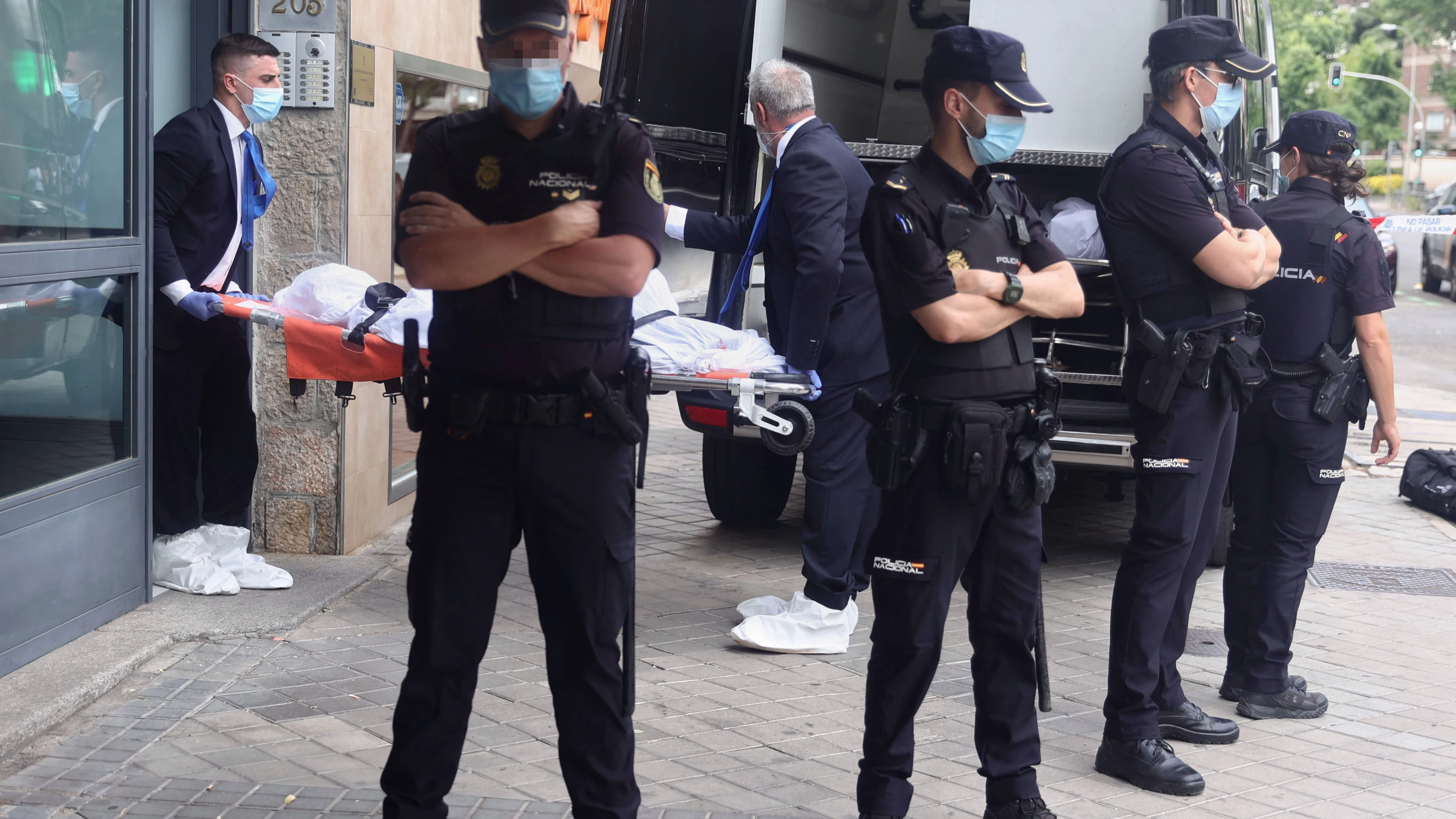 Un operario transporta el cuerpo de una de las tres personas halladas muertas a balazos en la vivienda Un operario transporta el cuerpo de una de las tres personas halladas muertas a balazos en la vivienda