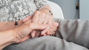 Imagen de archivo de dos personas mayores cogiéndose la mano