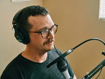 Hombre hablando a un micrófono Hombre hablando a un micrófono