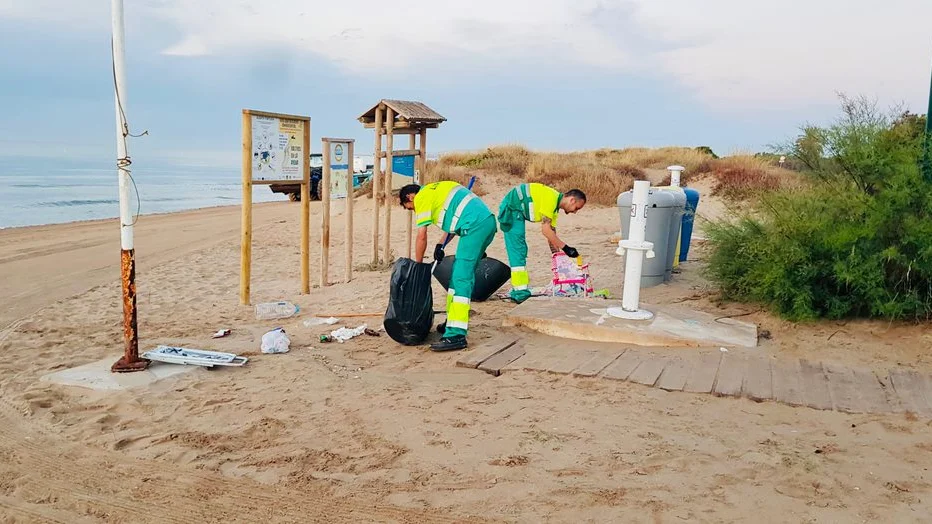 Operarios de limpieza en la playa de Los Arenales del Sol de Elche tras la noche de San Juan de 2022.