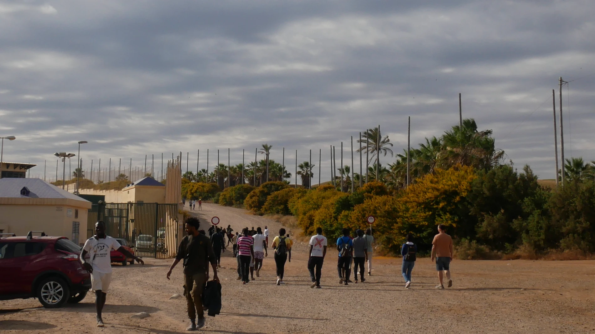 Varias decenas de inmigrantes se dirigen al Centro de Estancia Temporal de inmigrantes (CETI) tras entrar este viernes en Melilla tras romper la puerta de acceso al paso fronterizo de Barrio Chino