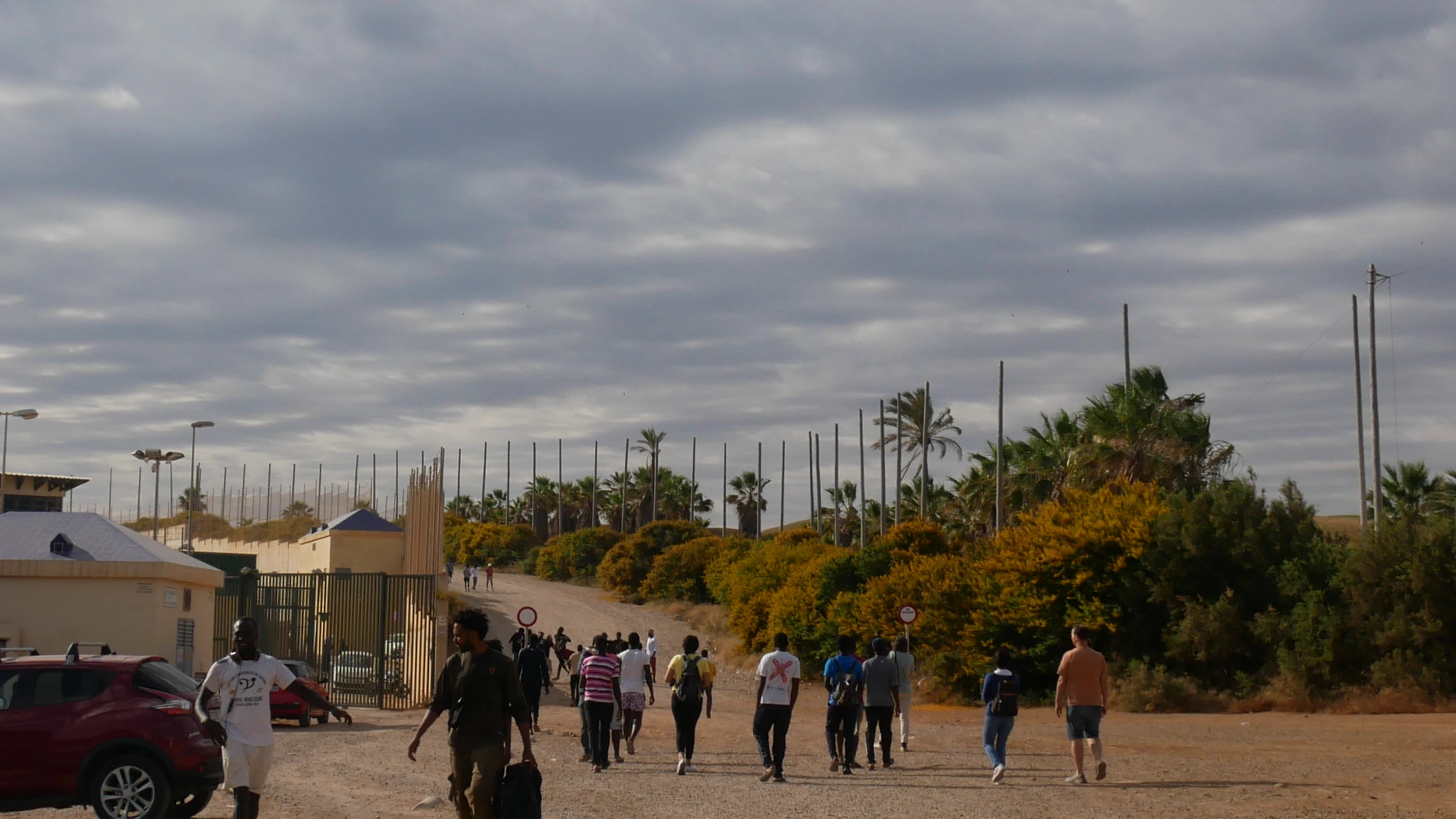 Varias decenas de inmigrantes se dirigen al Centro de Estancia Temporal de inmigrantes (CETI) tras entrar este viernes en Melilla tras romper la puerta de acceso al paso fronterizo de Barrio Chino