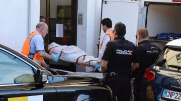 Agentes de la Policía Nacional y miembros del servicio forense retiran el cadáver de una mujer de 50 años asesinada por su hijo, de 16, en el domicilio en el que vivían en Valladolid, este jueves. 