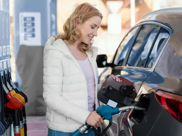 Fantasiosa imagen de stock de una chica echando gasolina y sonriendo Fantasiosa imagen de stock de una chica echando gasolina y sonriendo