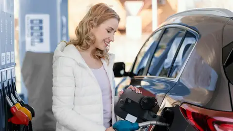 Fantasiosa imagen de stock de una chica echando gasolina y sonriendo Fantasiosa imagen de stock de una chica echando gasolina y sonriendo