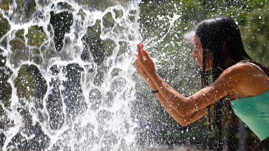 Una chica se refresca ante el calor Una chica se refresca ante el calor