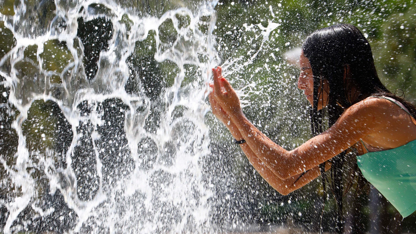 Una chica se refresca ante el calor Una chica se refresca ante el calor