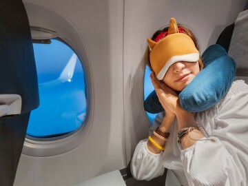 Chica durmiendo en el avión con cojín