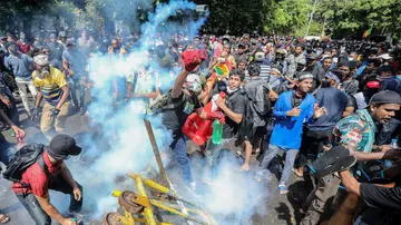 Las fuerzas de seguridad disparan gas lacrimógeno para dispersar a los manifestantes que intentan entrar en la oficina del primer ministro en Colombo, Sri Lanka