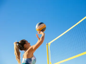 Una chica juega a voleibol en la playa. Una chica juega a voleibol en la playa.