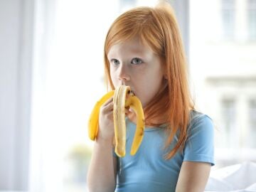 Niña comiendo un plátano